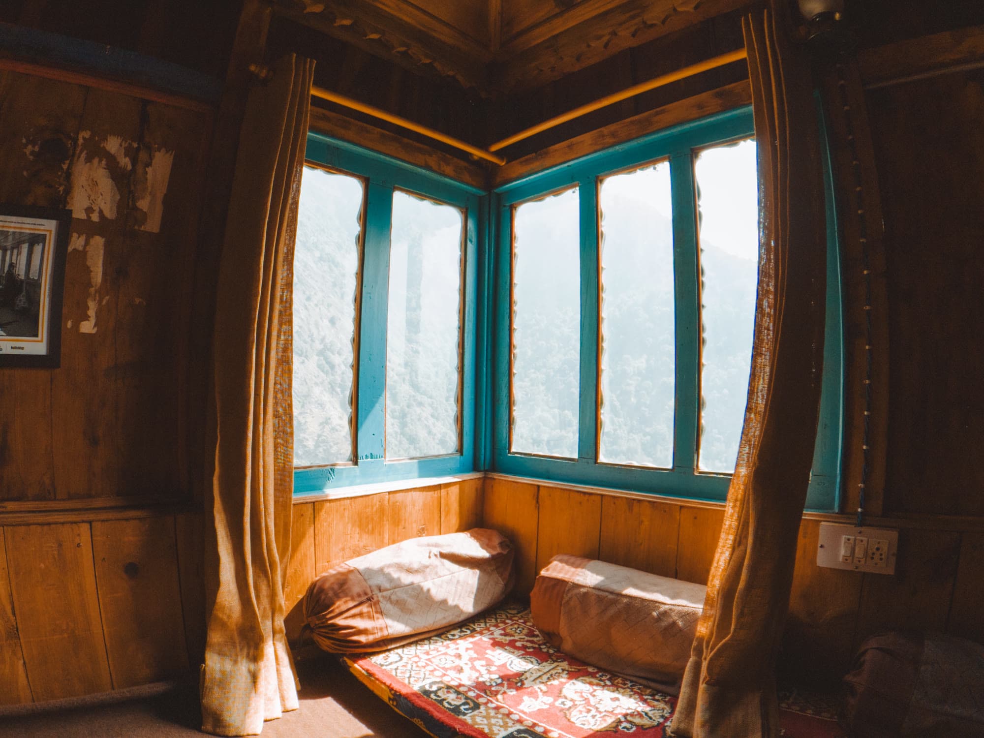 Corner windows looking out on the mountains, with cushions on the floor