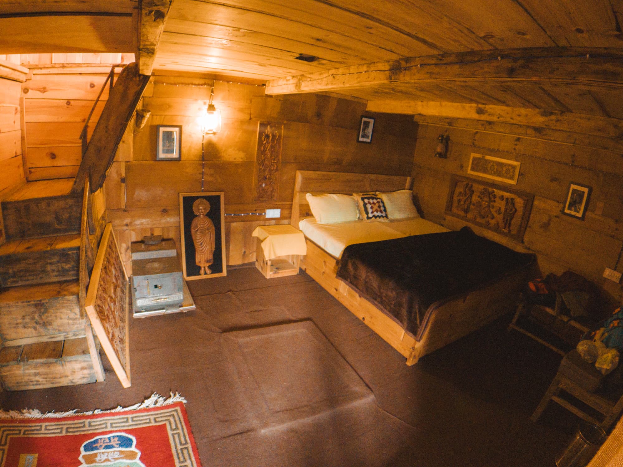 A wooden bedroom lit by a warm lamp